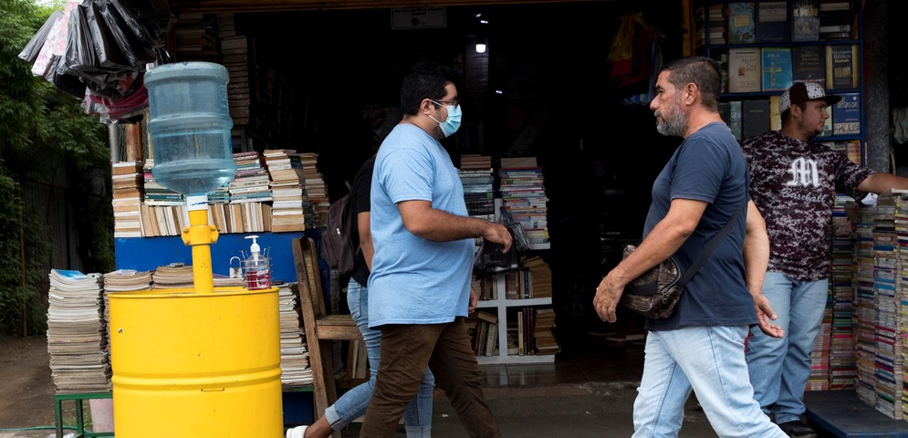 transeúntes que caminan frente a una librería en Managua