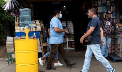 transeúntes que caminan frente a una librería en Managua