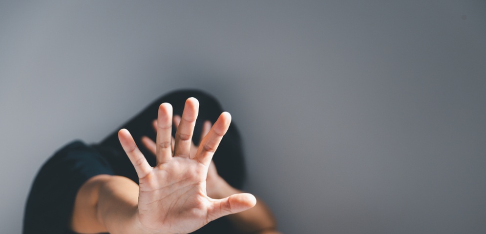 mujer violentada tapandose la cara