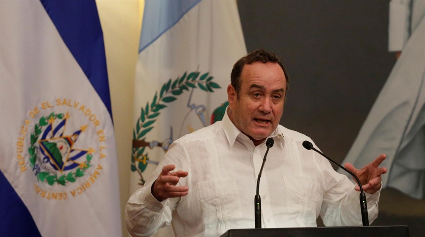 alejandro giammattei con la bandera de guatemala de fondo