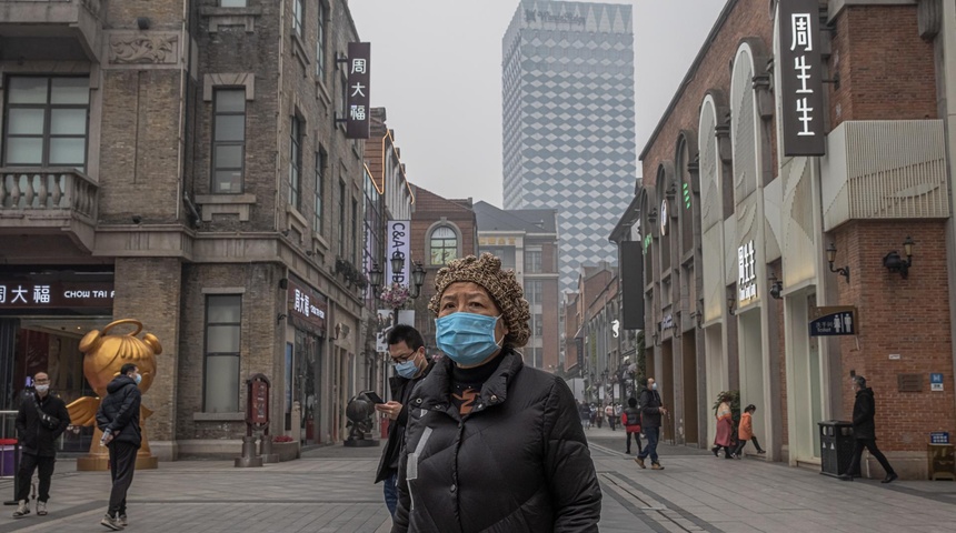 mujer con mascarilla en Wuhan, China