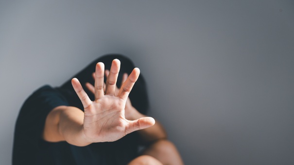 mujer violentada tapandose la cara