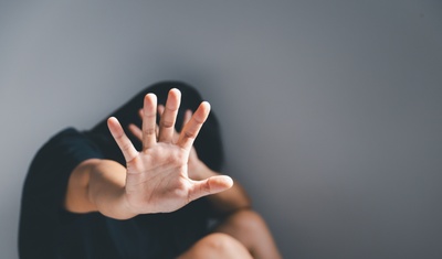 mujer violentada tapandose la cara