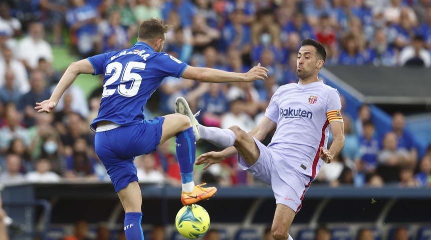 El centrocampista del FC Barcelona, Sergio Busquets (d), ante el delantero del Getafe, Borja Mayoral.