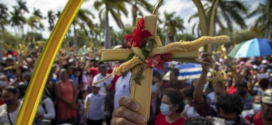 hombre sostiene una cruz de palma durante la misa del Domingo de Ramos