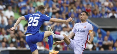 El centrocampista del FC Barcelona, Sergio Busquets (d), ante el delantero del Getafe, Borja Mayoral.