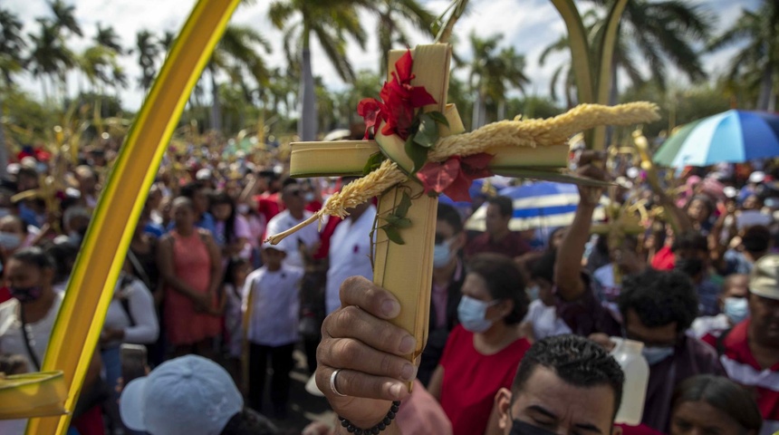 hombre sostiene una cruz de palma durante la misa del Domingo de Ramos