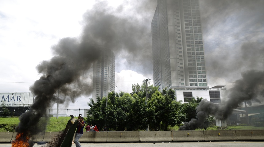 Un hombre carga un elemento para avivar una barricada en llamas durante una protesta, este 19 de julio de 2022, en Ciudad de Panamá (Panamá).