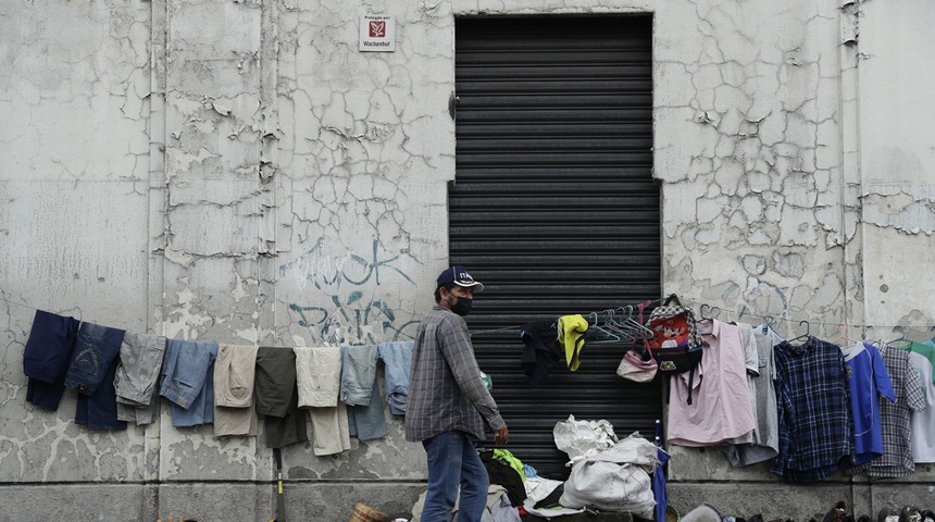 Un hombre ofrece diversos productos usados en su puesto de venta en una calle, el 8 de julio de 2022, en San Salvador (El Salvador).