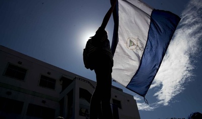 joven sostiene bandera nicaragüense