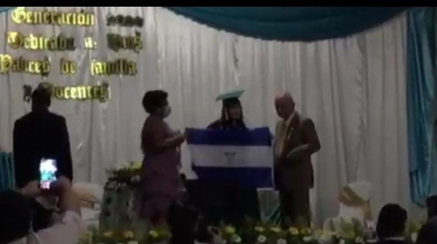 Mejor bachiller de Somoto alza bandera con escudo invertido en promoción, protesta contra el régimen