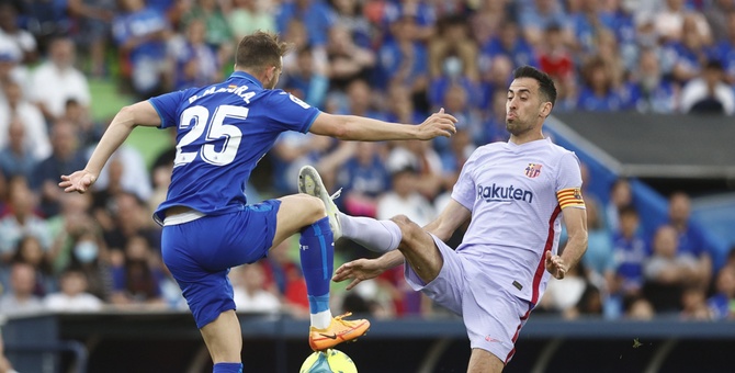 El centrocampista del FC Barcelona, Sergio Busquets (d), ante el delantero del Getafe, Borja Mayoral.