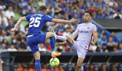 El centrocampista del FC Barcelona, Sergio Busquets (d), ante el delantero del Getafe, Borja Mayoral.