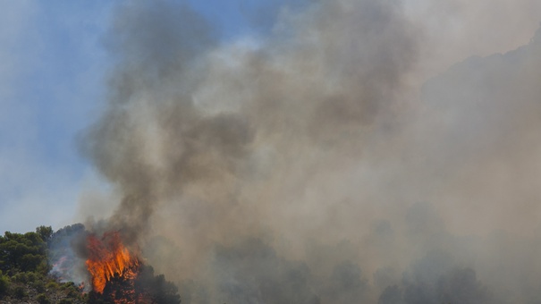 Un helicóptero del servicio de bomberos trabaja en el incendio declarado en la sierra de Mijas, Málaga.