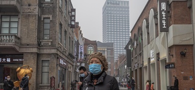 mujer con mascarilla en Wuhan, China