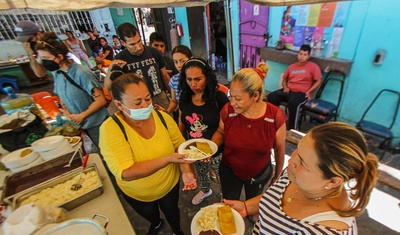 Migrantes reciben comida en albergue "La roca de la Salvación", en Tijuana, Baja California, México.