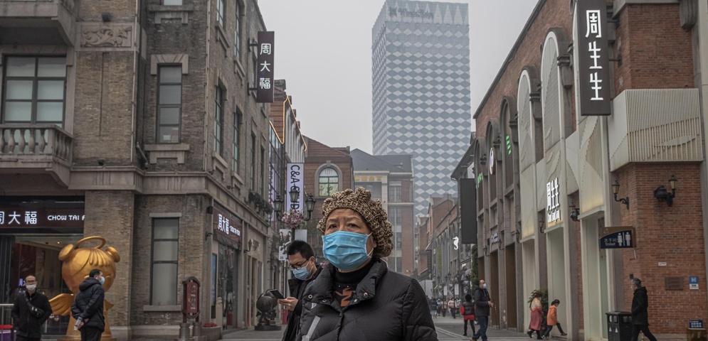 mujer con mascarilla en Wuhan, China