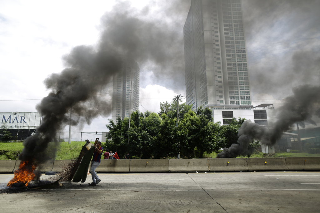 Un hombre carga un elemento para avivar una barricada en llamas durante una protesta, este 19 de julio de 2022, en Ciudad de Panamá (Panamá).