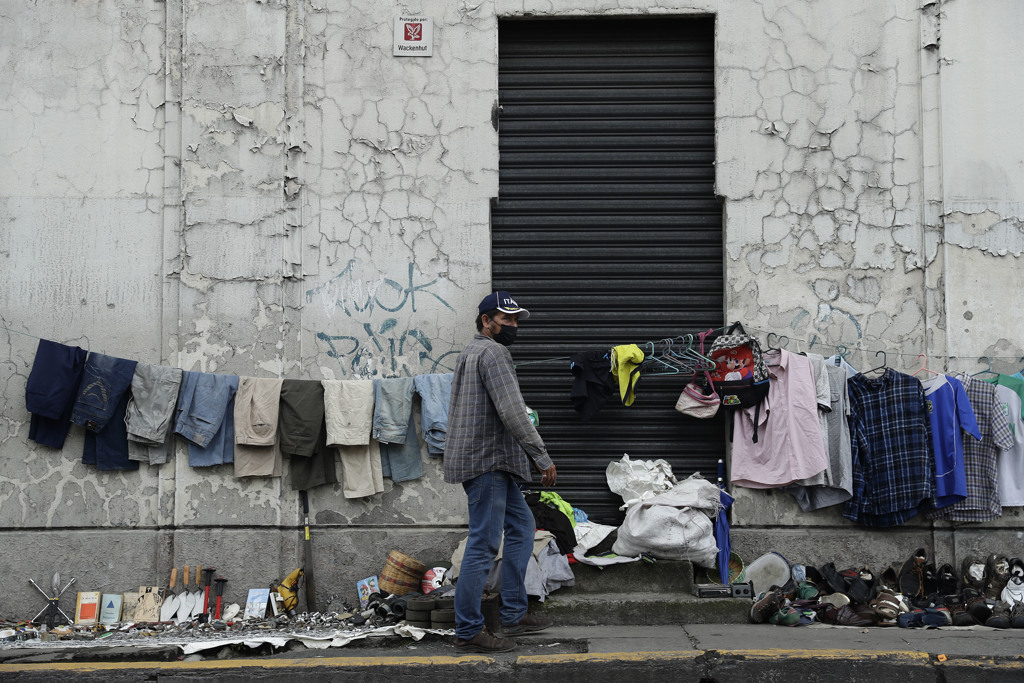 Un hombre ofrece diversos productos usados en su puesto de venta en una calle, el 8 de julio de 2022, en San Salvador (El Salvador).
