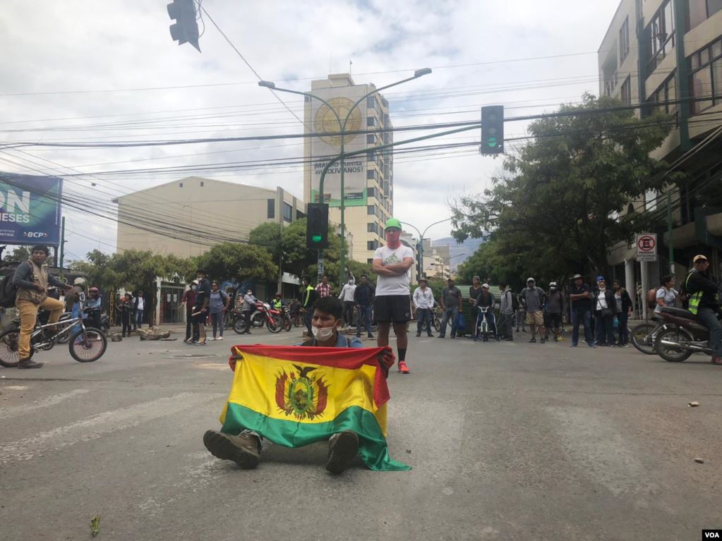 Una persona despliega la bandera de Bolivia en la protesta que se llevó a cabo en Cochabamba.